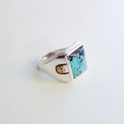A Sterling Silver signet ring featuring a square Hubei turquoise stone with dark matrix, accented by a small 18K Gold bosses on the band, set against a plain white background.