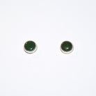 A pair of round stud earrings with dark green cabochon stones set in silver bezel settings, shown on a plain white background.