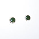 A pair of round stud earrings with dark green cabochon stones set in silver, shown on a plain white background.