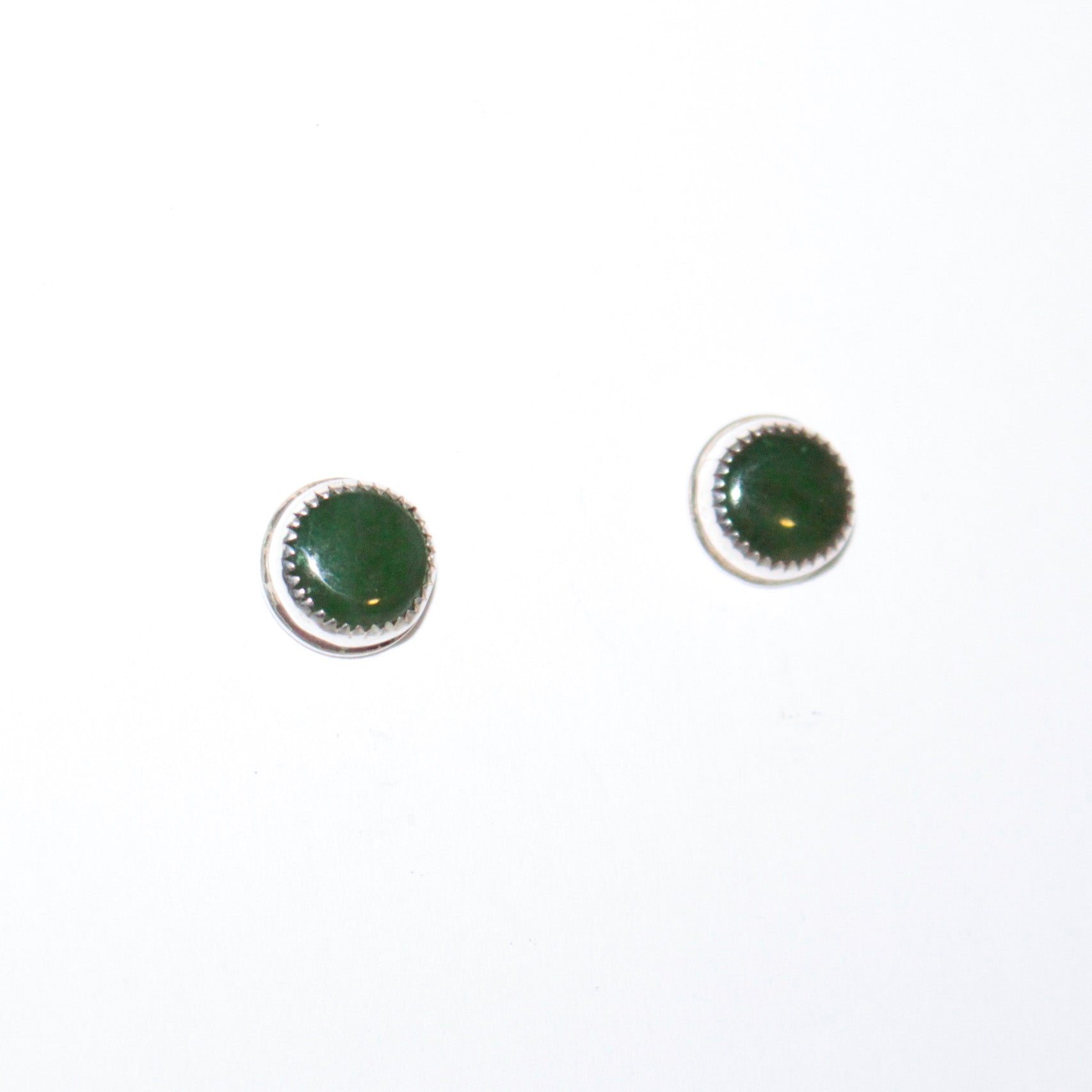 A pair of round stud earrings with dark green cabochon stones set in silver, shown on a plain white background.