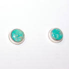 A pair of round stud earrings featuring turquoise stones in silver bezel settings, displayed on a plain white background.