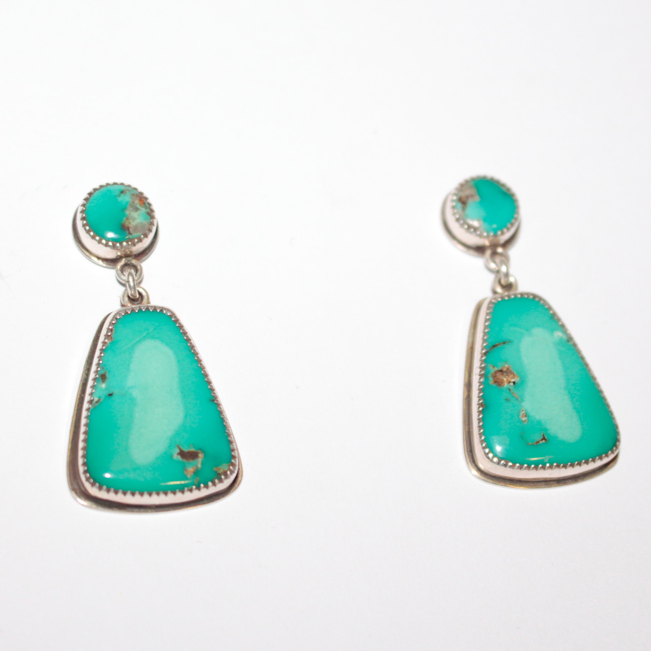 A pair of Sterling Silver dangle earrings featuring oval and teardrop-shaped Fox Turquoise stones with natural matrix inclusions, set against a plain white background.