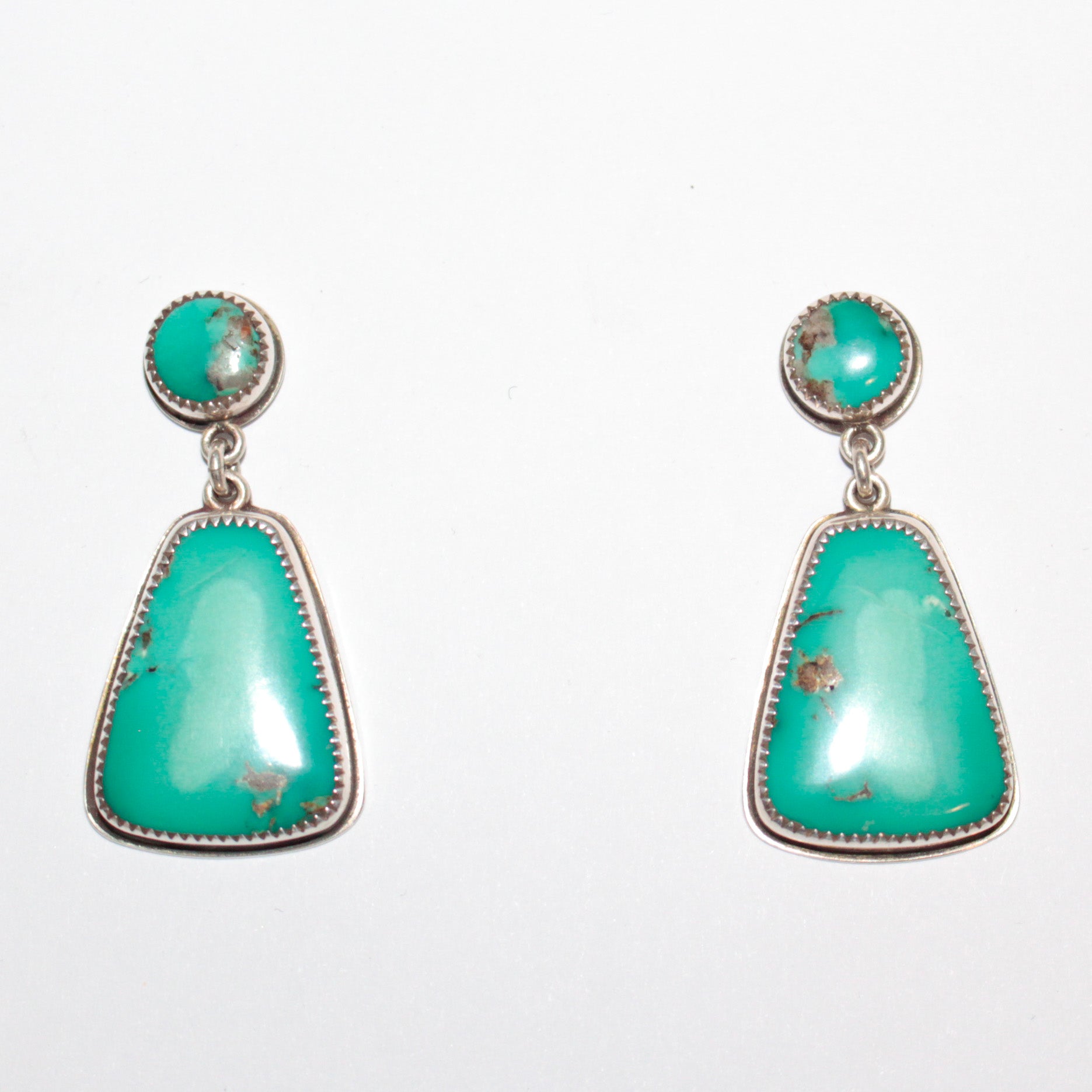 A pair of Sterling Silver dangle earrings featuring oval and teardrop-shaped Fox Turquoise stones with natural matrix inclusions, set against a plain white background.