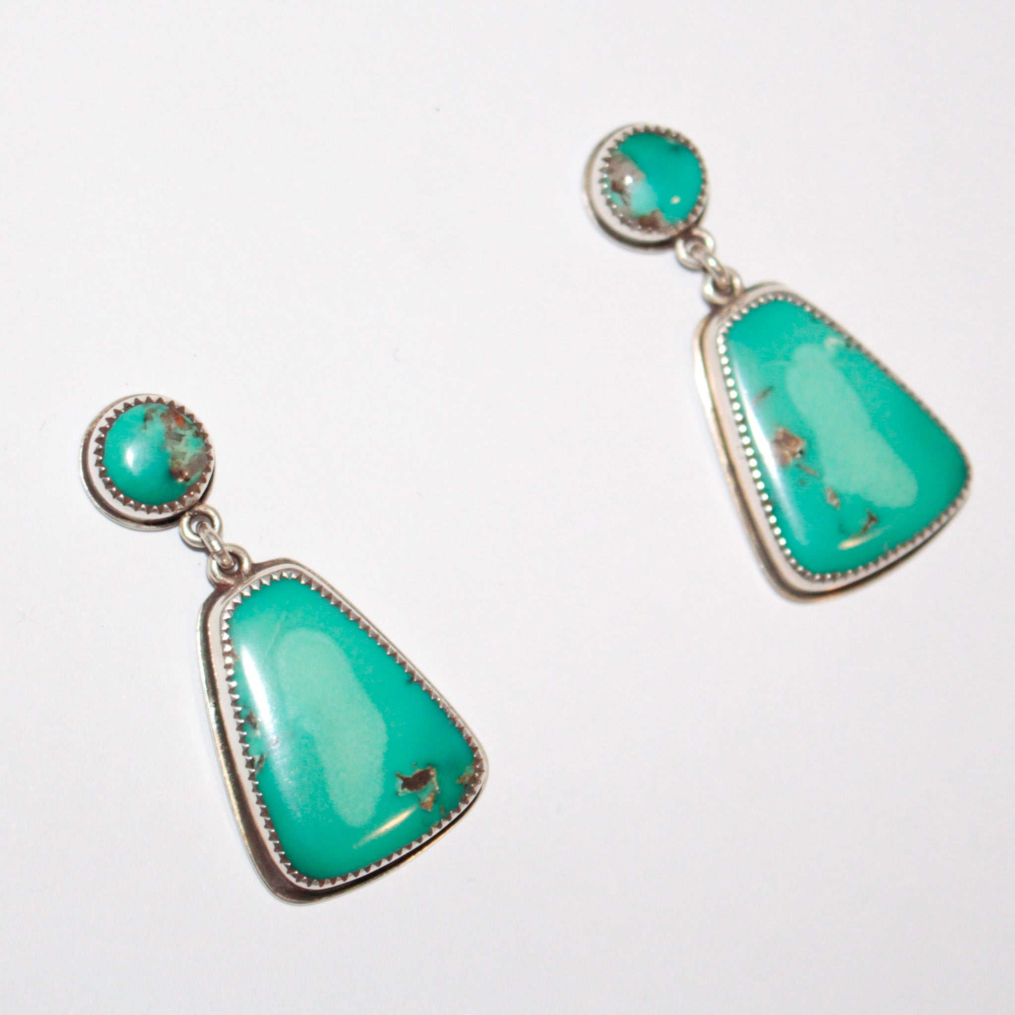 A pair of Sterling Silver dangle earrings featuring oval and teardrop-shaped Fox Turquoise stones with natural matrix inclusions, set against a plain white background.