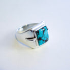 A sterling silver ring featuring a square-cut hubei turquoise stone with natural black veining, set in a modern geometric bezel on a plain white background.