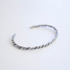 A twisted Sterling Silver wire cuff bracelet with displayed on a clean white background.