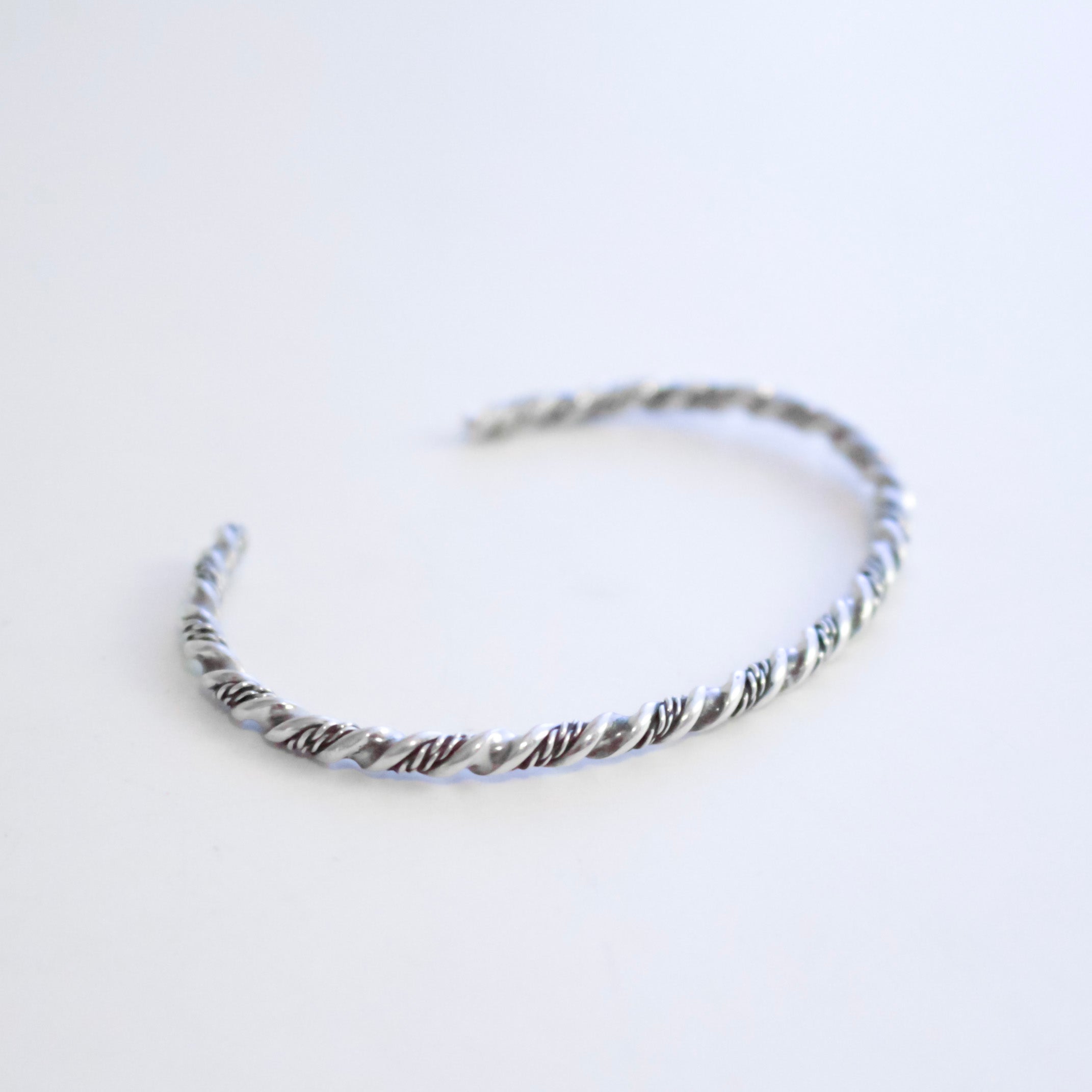 A twisted Sterling Silver wire cuff bracelet with displayed on a clean white background.