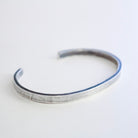 A square, matte finish 995 silver cuff bracelet with an open end, photographed on a clean white background.