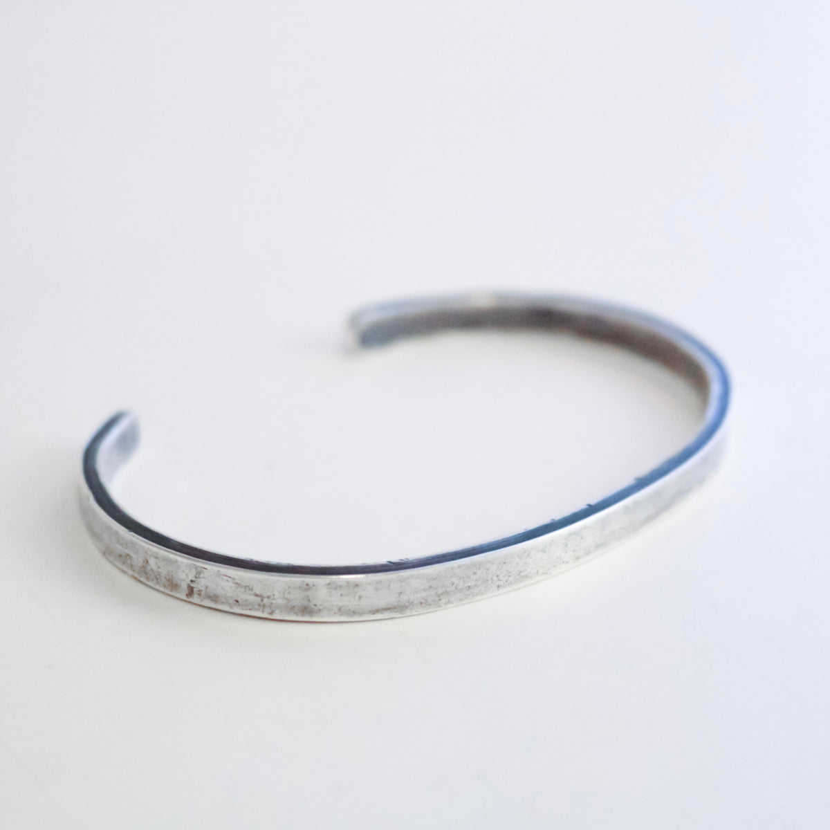 A square, matte finish 995 silver cuff bracelet with an open end, photographed on a clean white background.