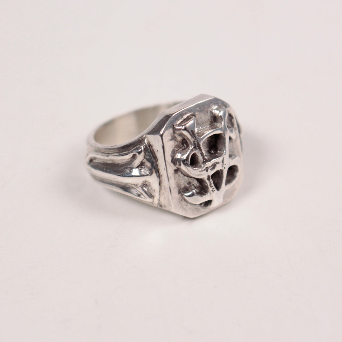 A sterling silver signet ring with a highly textured, openwork Savoir Vivre initials design on the face and a polished band, shown on a plain off-white background.