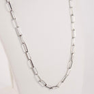 A handmade sterling silver paperclip link chain necklace displayed on a white mannequin bust against a light gray background.