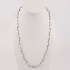 A handmade sterling silver paperclip link chain necklace displayed on a white mannequin bust against a light gray background.